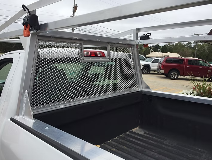Silver truck bed rack with a wire mesh window guard.