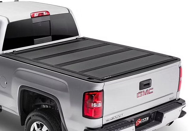 Silver GMC truck with a black folding tonneau cover.