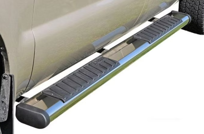 Running board on a light-colored truck. It has a chrome finish and black rubber steps.