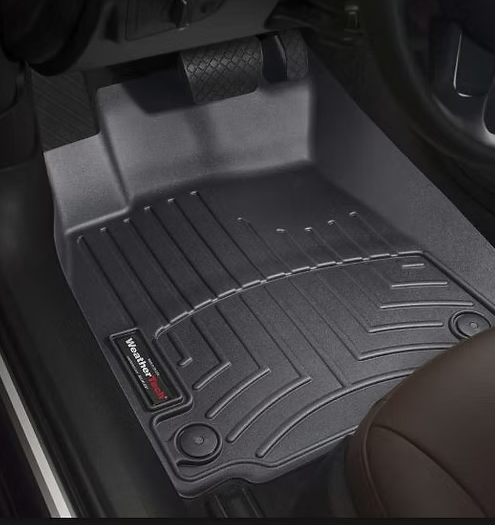 Black WeatherTech floor mat in a car.