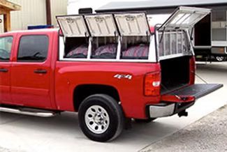 Red pickup truck with a dog kennel enclosure, open doors.