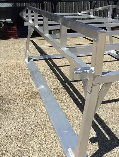 Aluminum metal frame, possibly a trailer bed, on a sunny day.