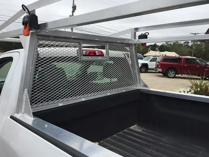 White truck bed with a metal mesh headboard and roof rack.