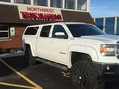 White pickup truck with a camper shell parked in front of 