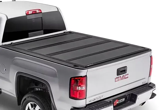 Silver pickup truck with a black, folding tonneau cover.