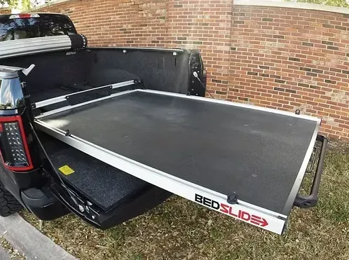 Black truck bed with a sliding cargo tray extended. 