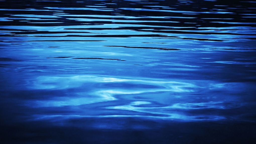 Blue rippling water with shimmering light reflections