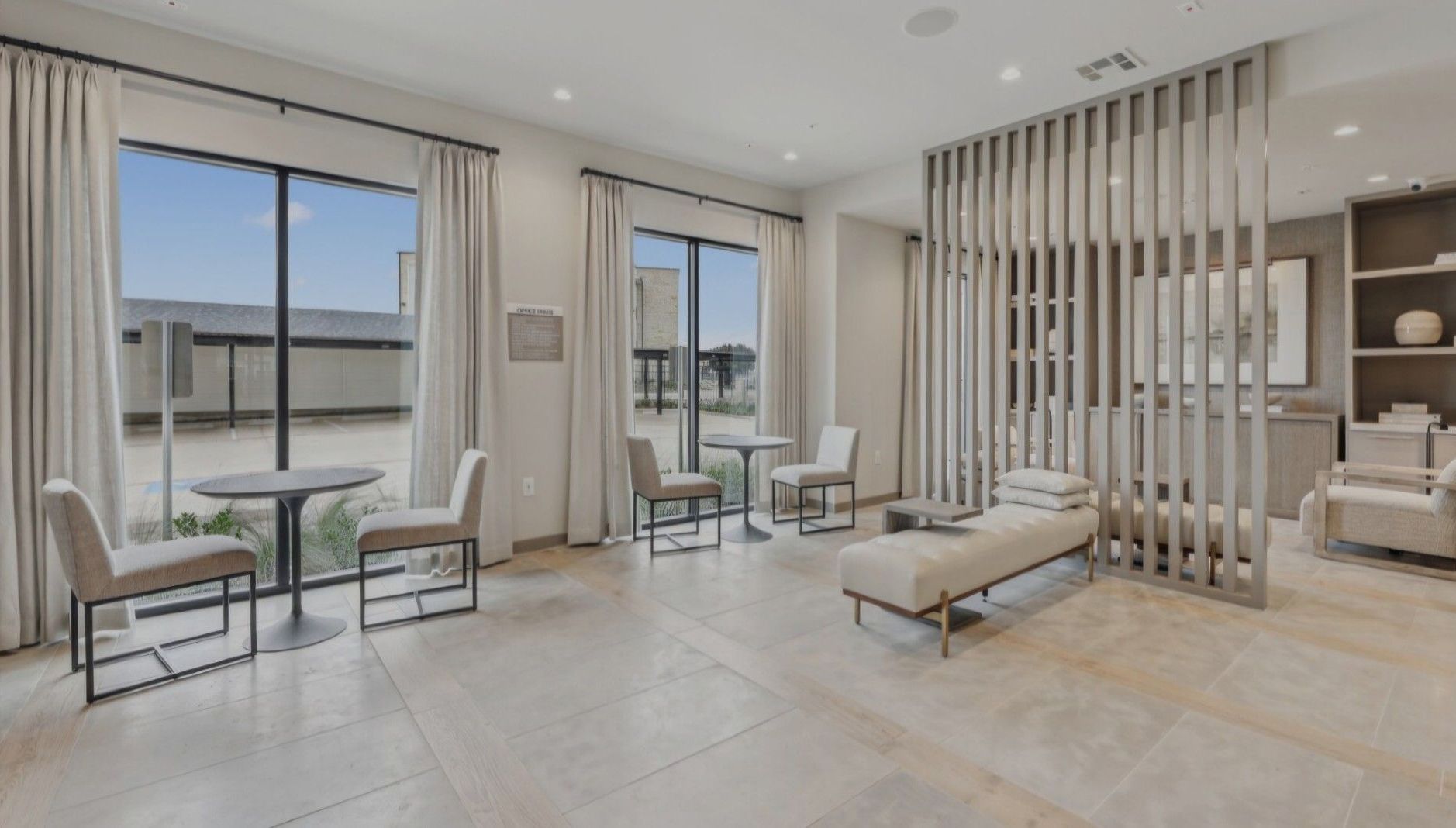 A living room with tables, chairs, and a bench.