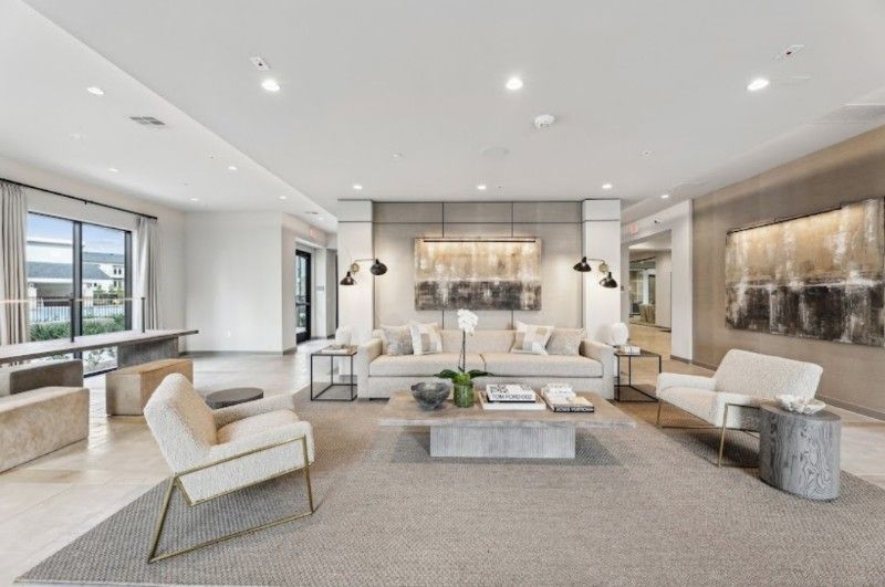 A living room with a couch , chairs , and a coffee table.