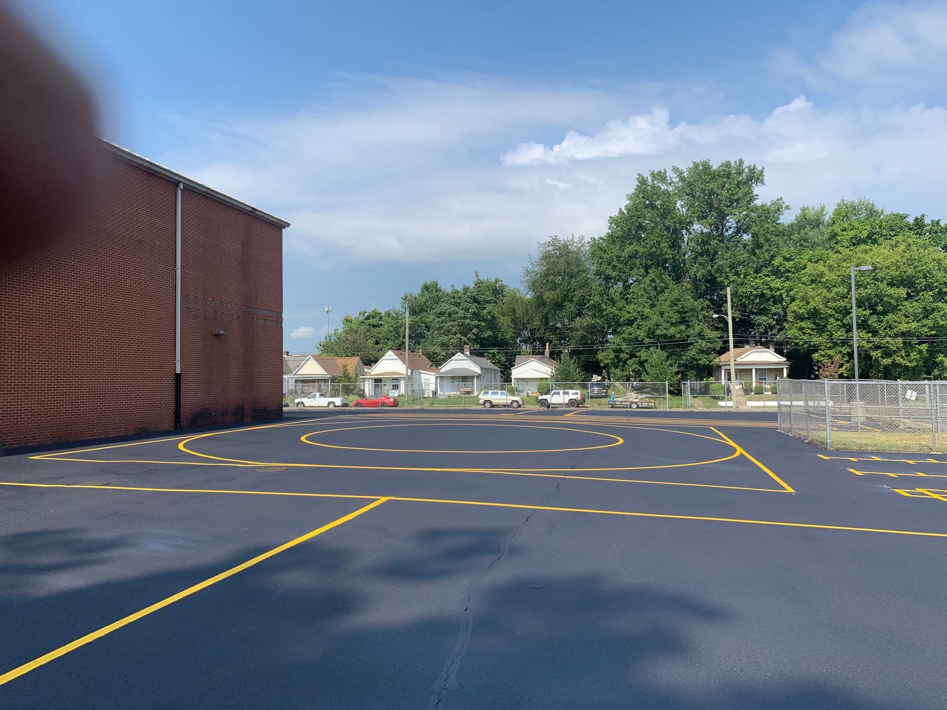 A parking lot with a brick building in the background.