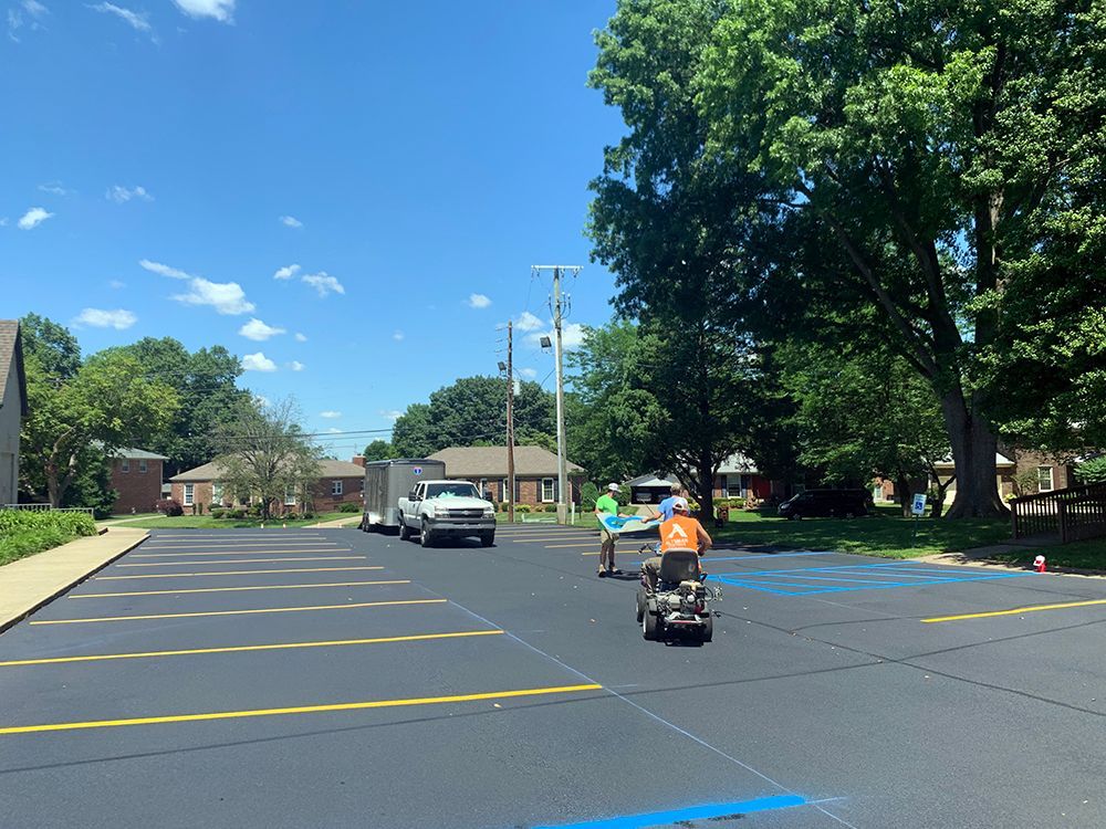 A man is riding a scooter in a parking lot.