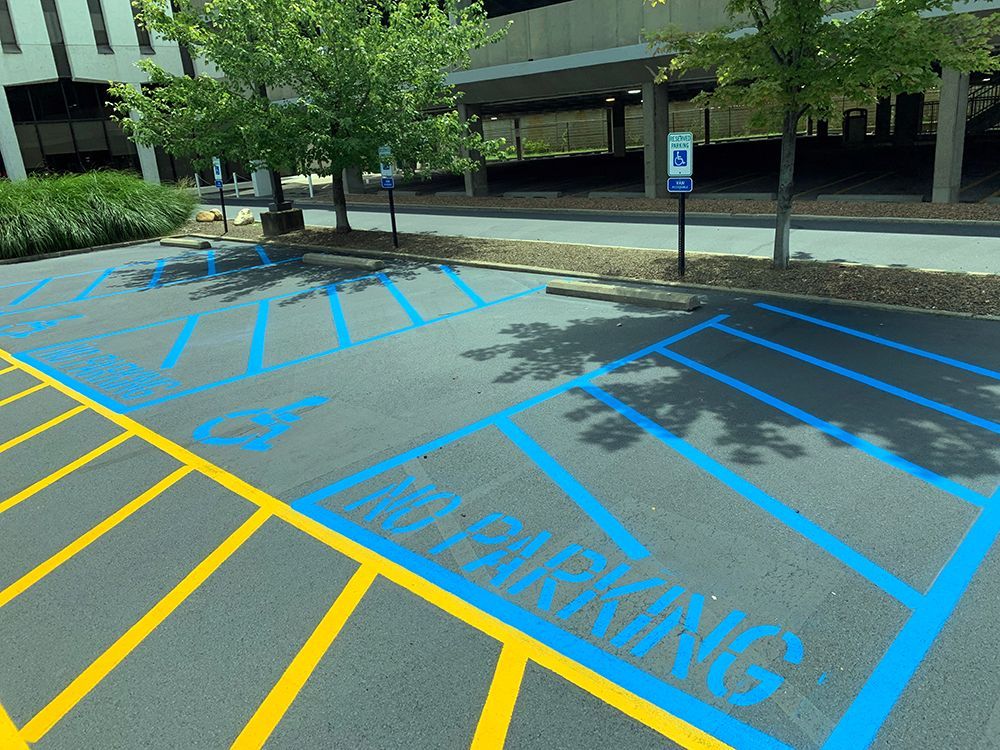 A parking lot has a handicapped parking spot painted in blue