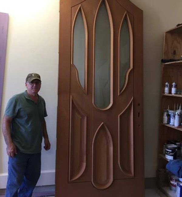 A man standing in front of a large wooden door