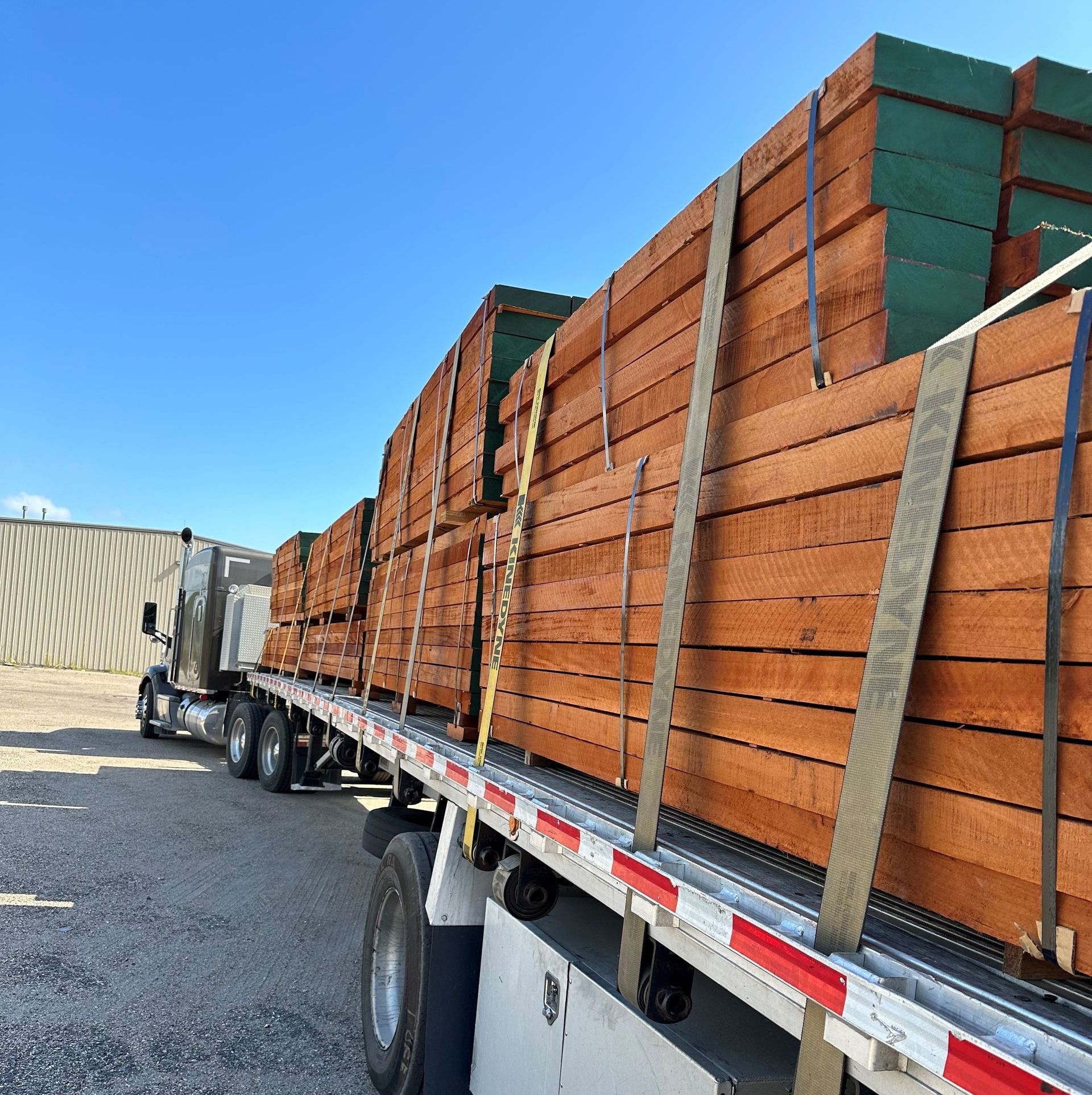 A semi truck is loaded with lots of wood