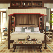 A bedroom with a canopy bed and a bench