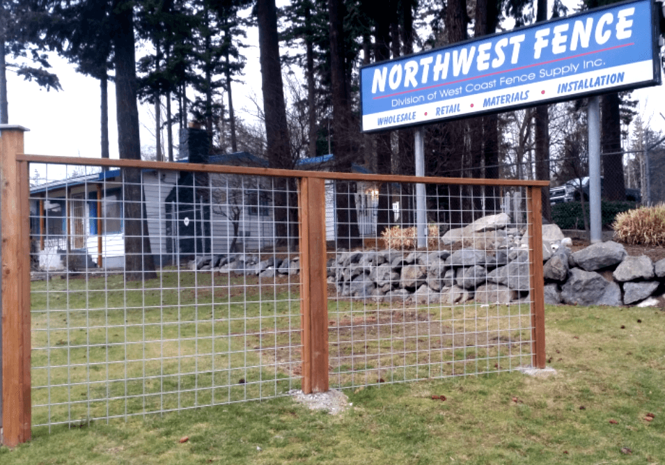 Wooden fence with wire mesh in front of the Northwest Fence sign.