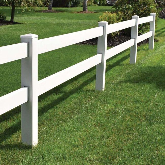 White vinyl fence on green grass, sunny day.
