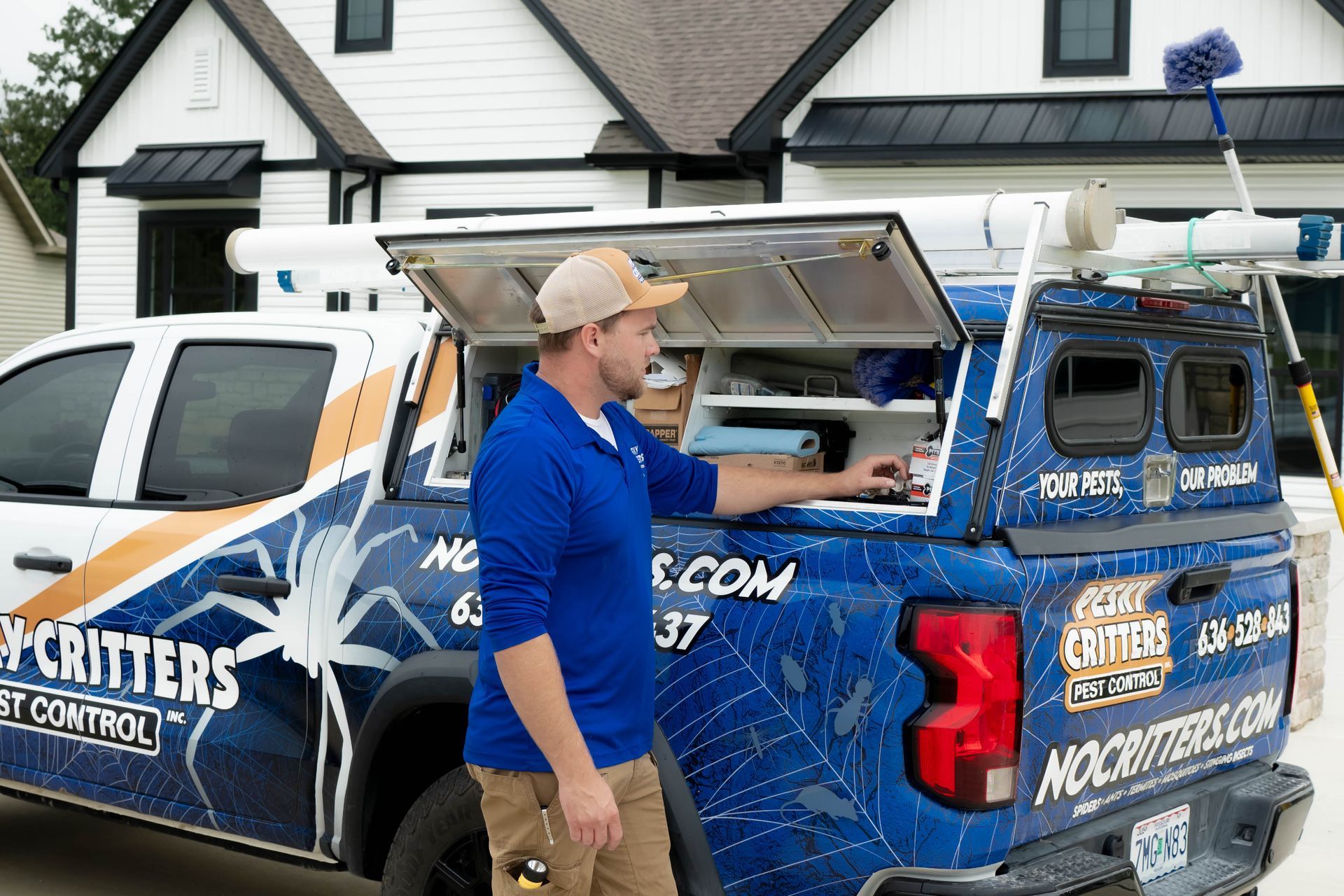 A worker in a blue polo shirt accesses equipment in a branded 