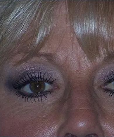 Close-up of a person's eyes, with light eyeshadow and mascara, showing wrinkles.