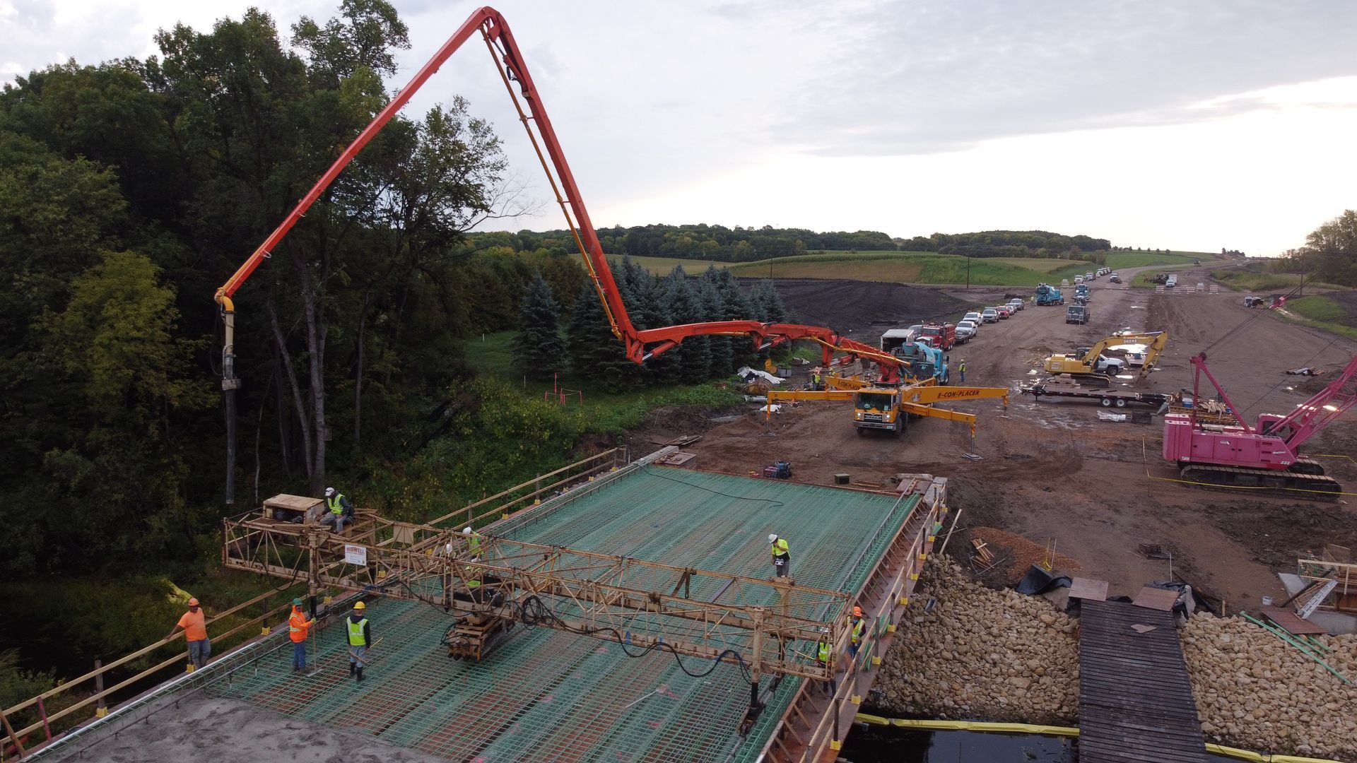 A concrete pump is being used to pour concrete on a bridge under construction.