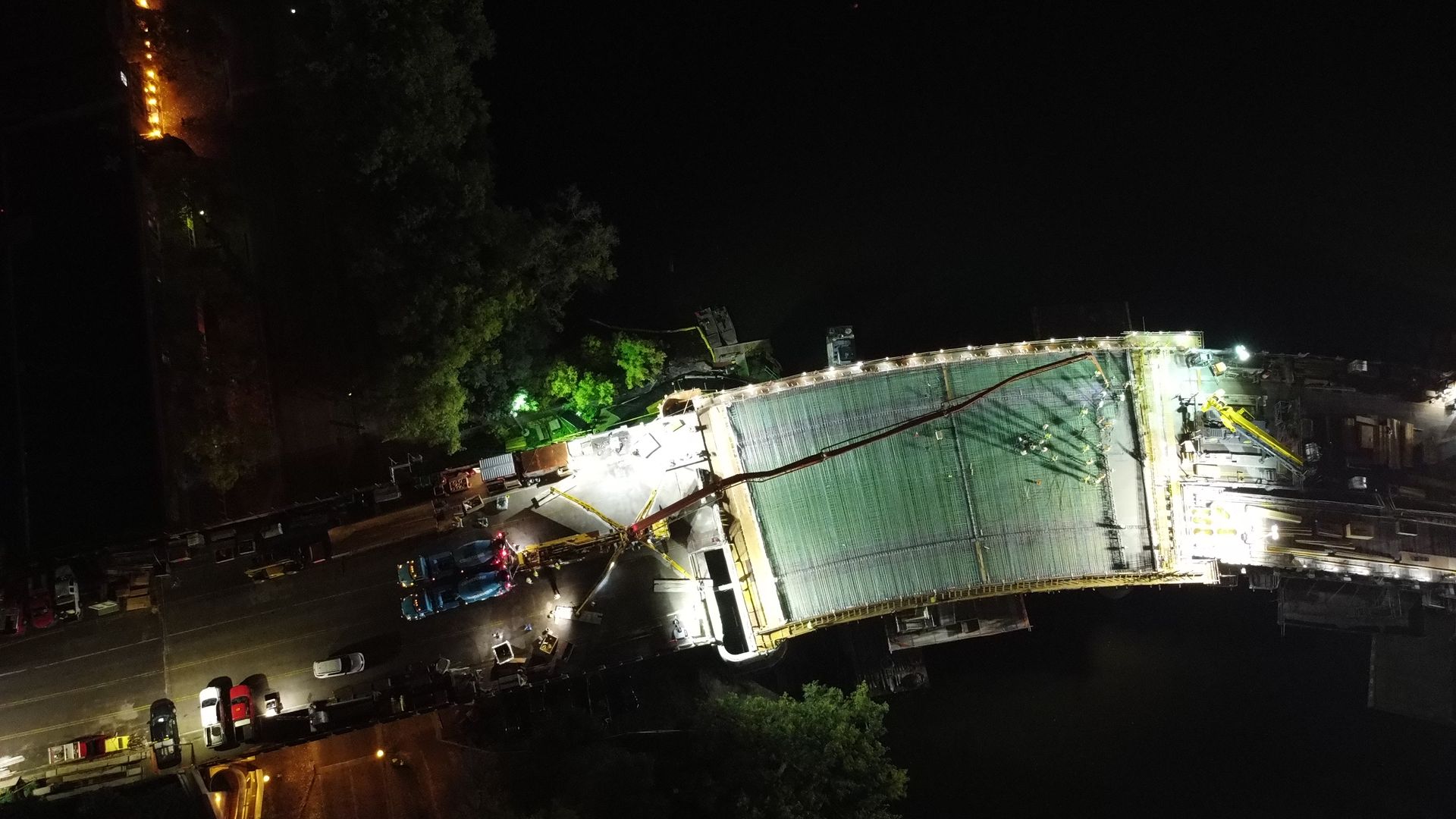 An aerial view of a bridge under construction at night.