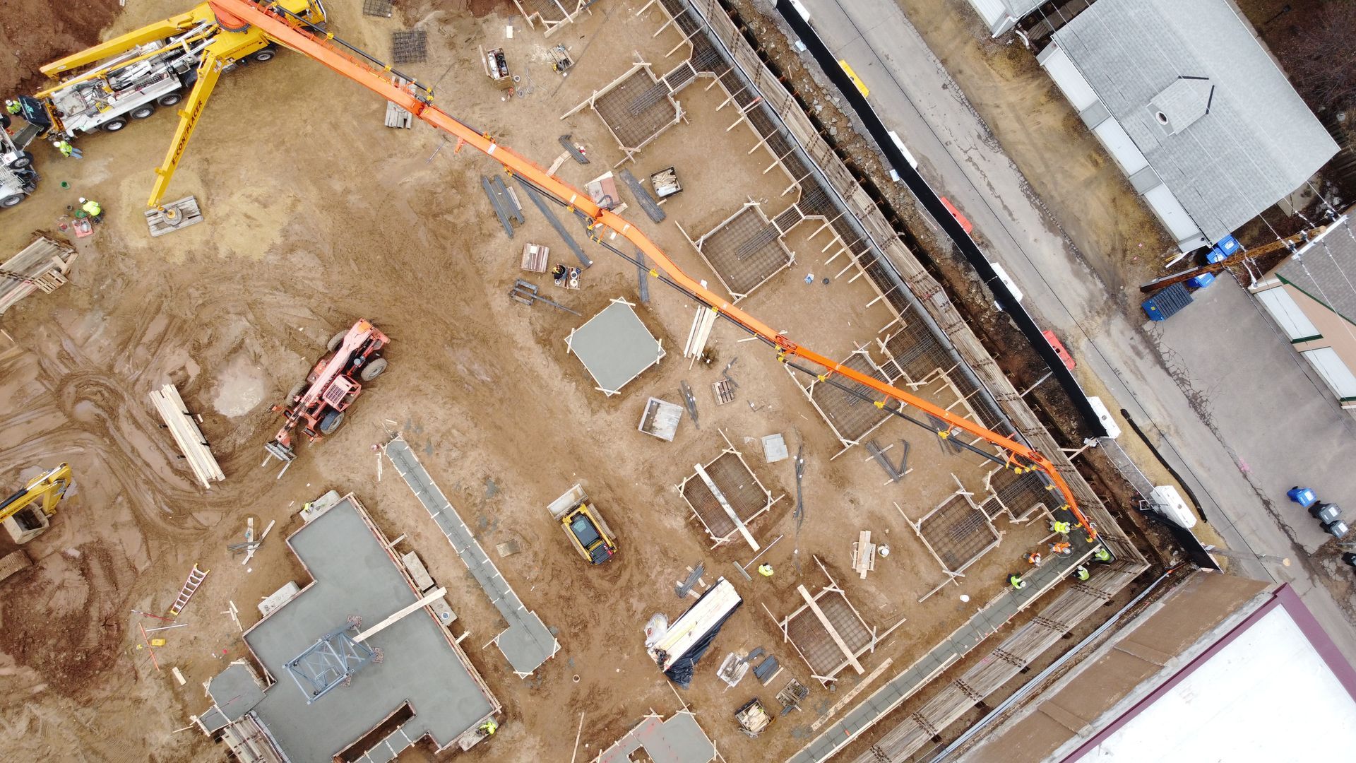 An aerial view of a construction site with a concrete pump.