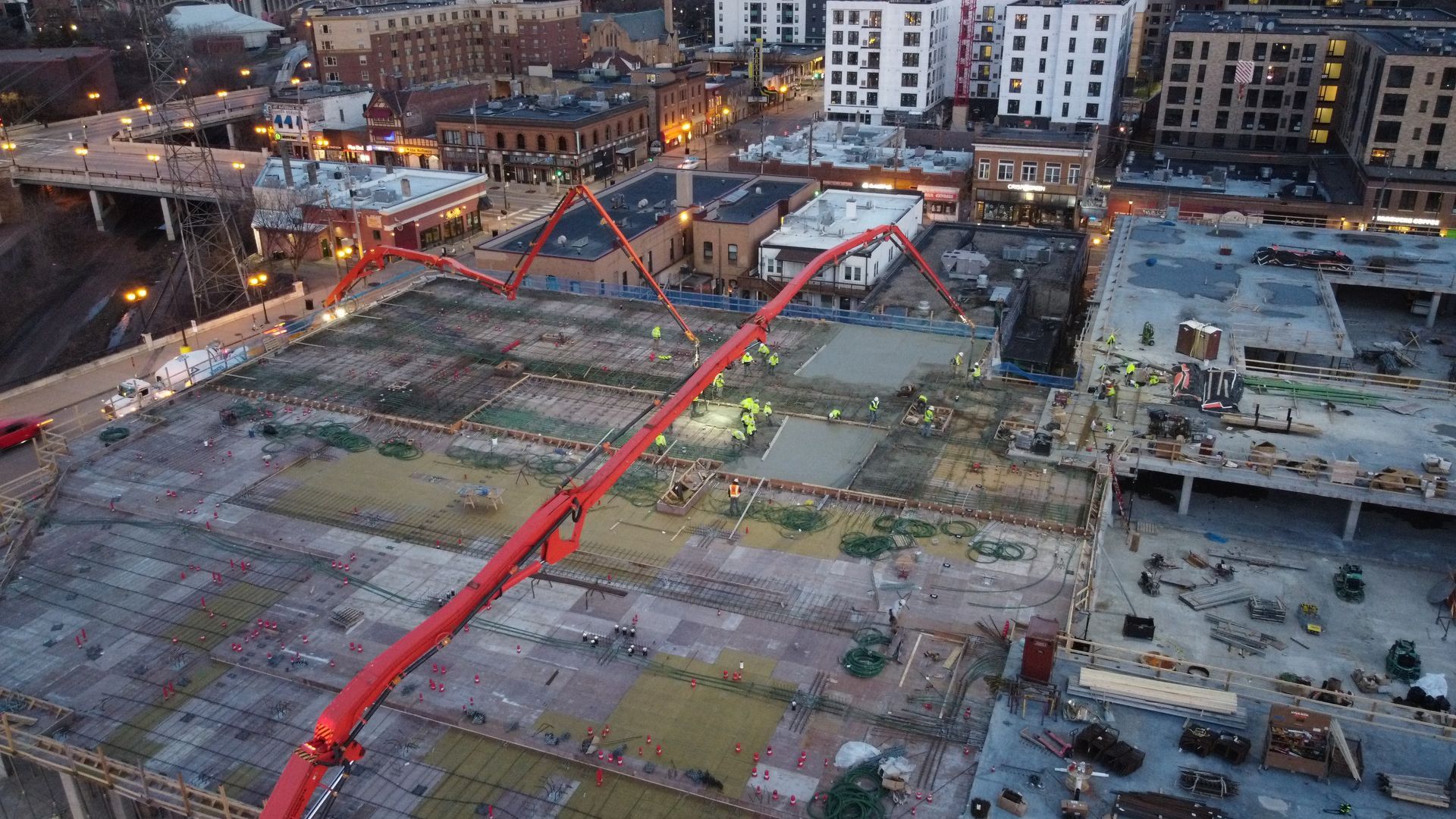 An aerial view of a construction site with a red crane.