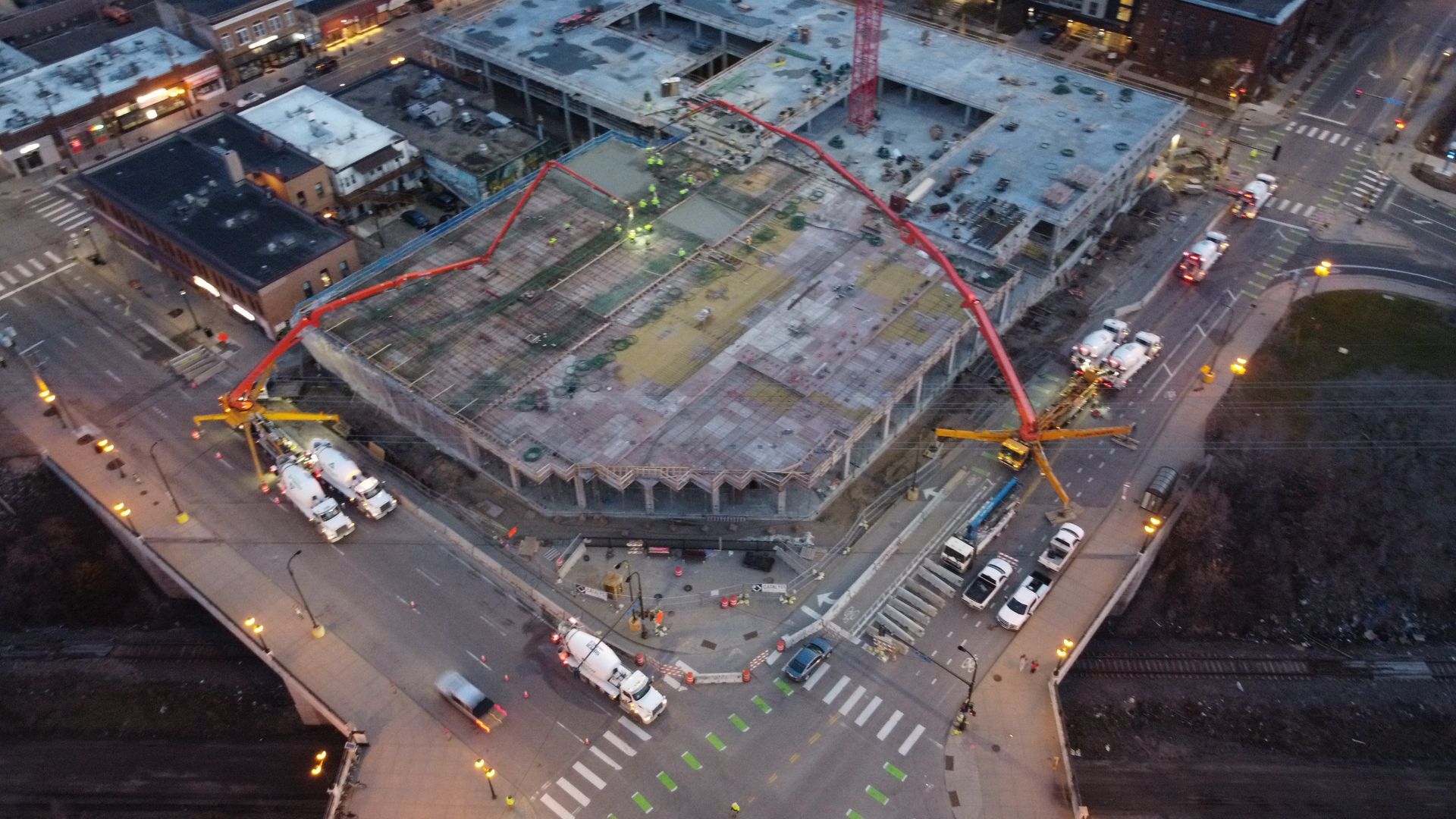 An aerial view of a building under construction in a city at night.