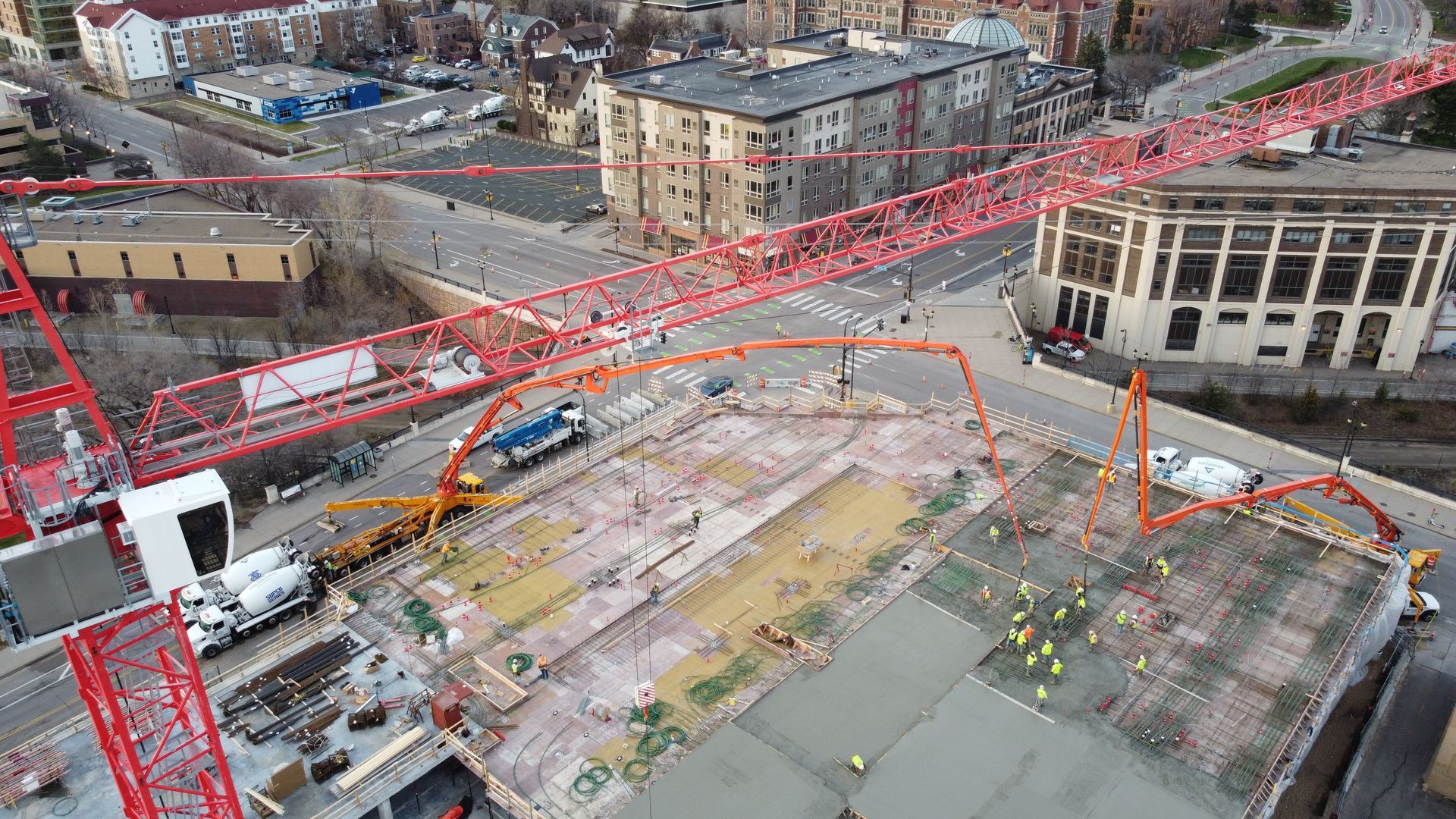 An aerial view of a construction site with a crane pumping concrete.