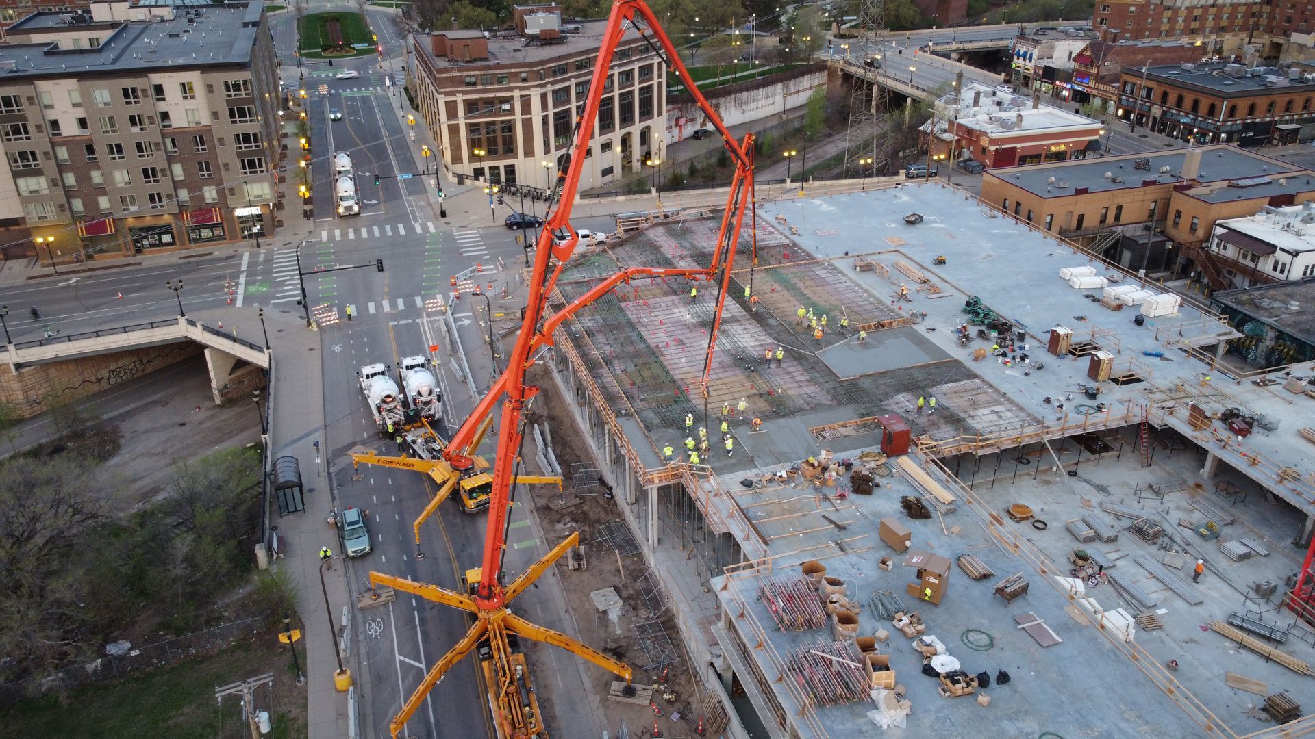 An aerial view of a construction site with a crane pumping concrete.