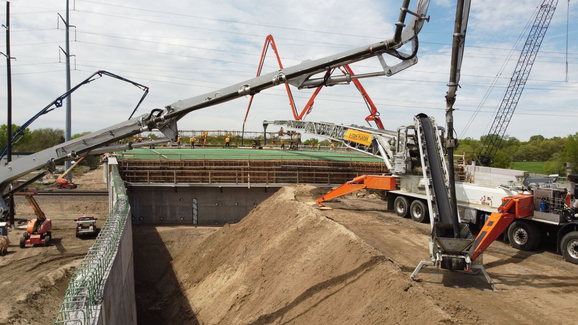 A concrete pump is being used to pour concrete into a hole at a construction site.