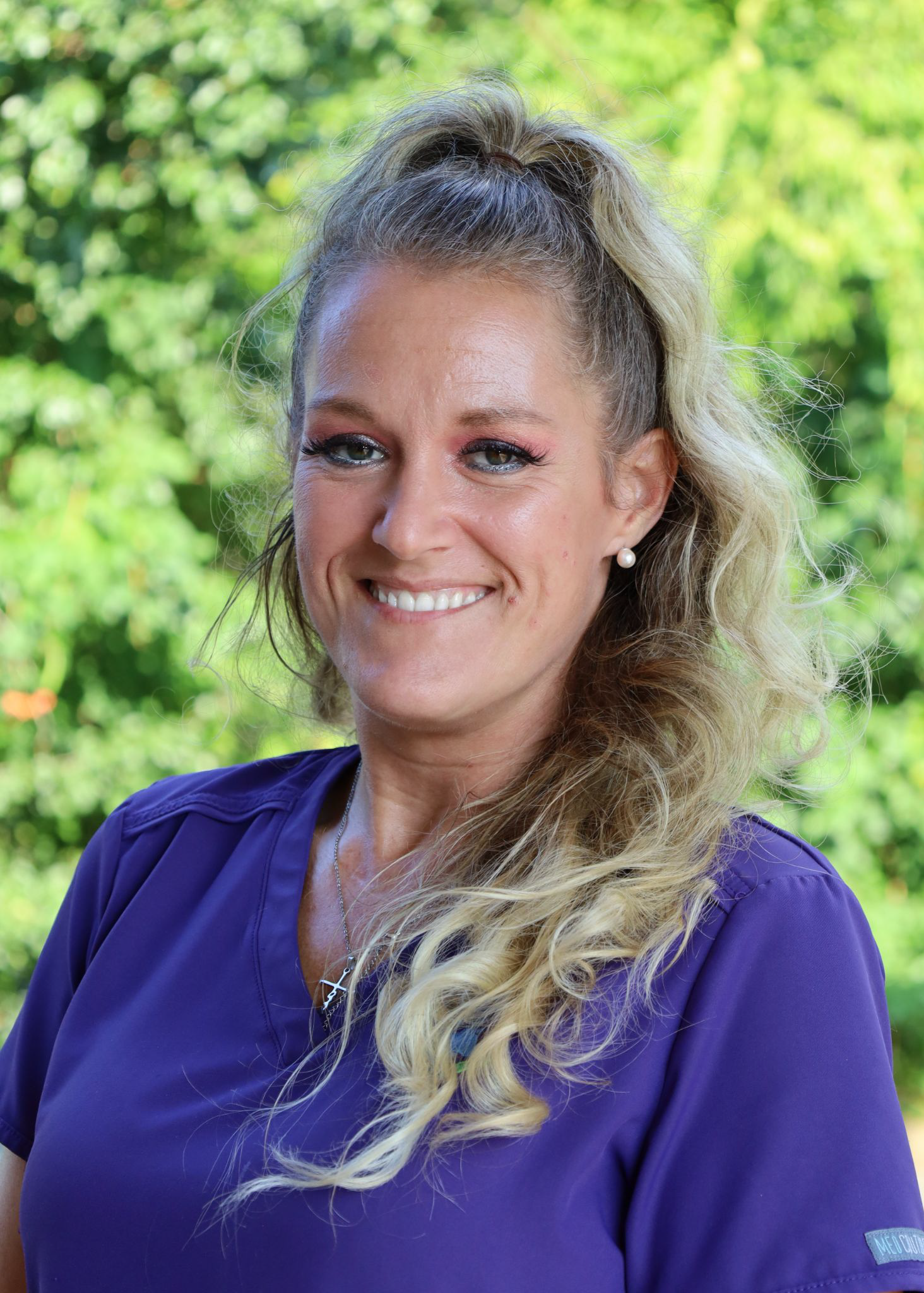 Smiling Black man in a suit and tie, against a gray backdrop.