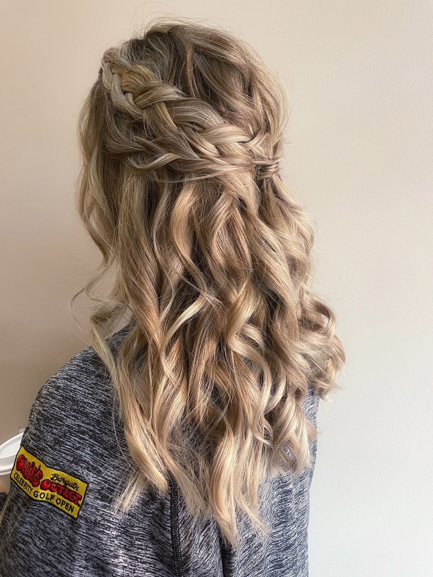 a woman with long blonde hair is wearing a half-up-half-down hairstyle