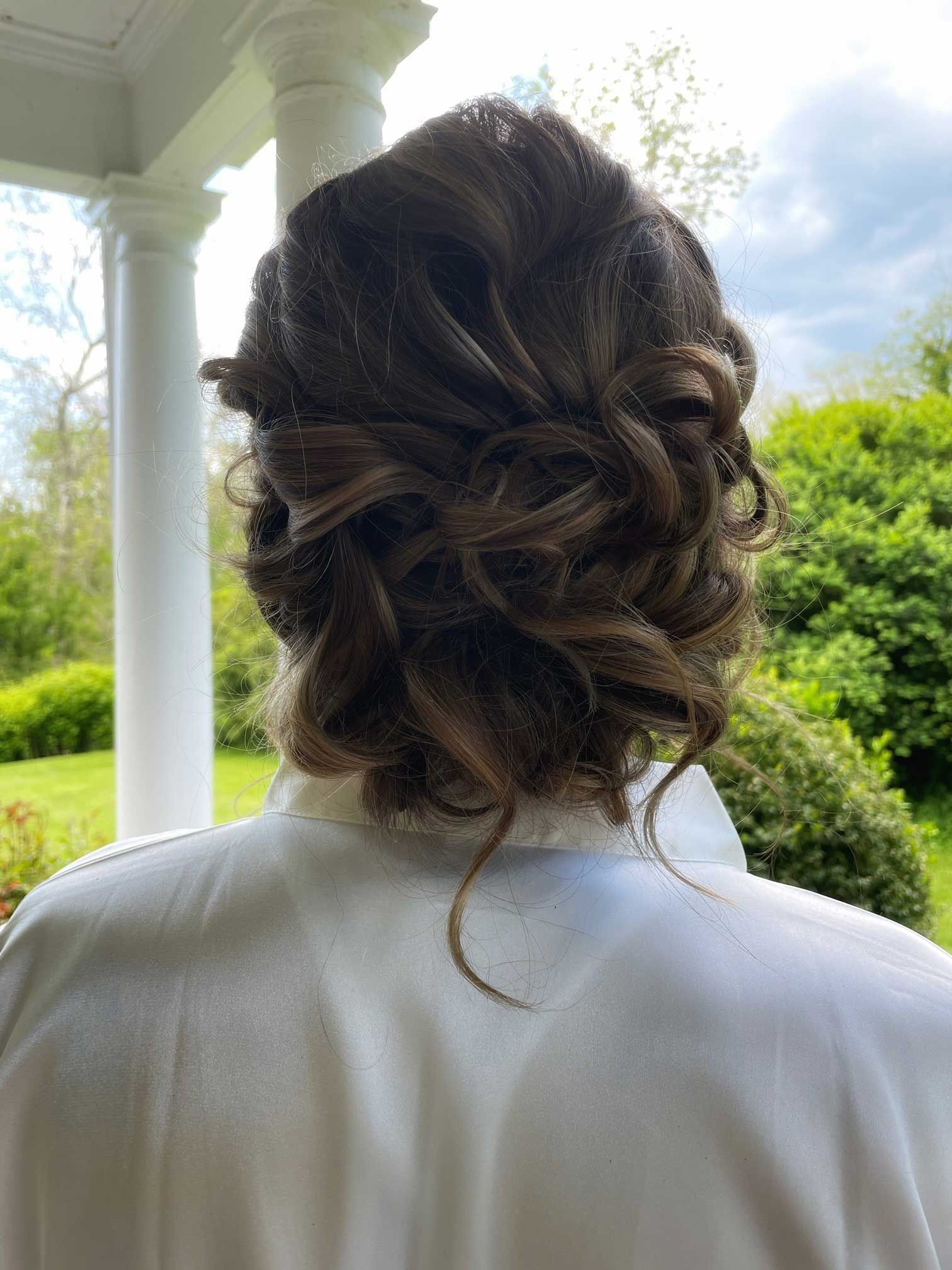 a woman with her hair in a bun is standing on a porch
