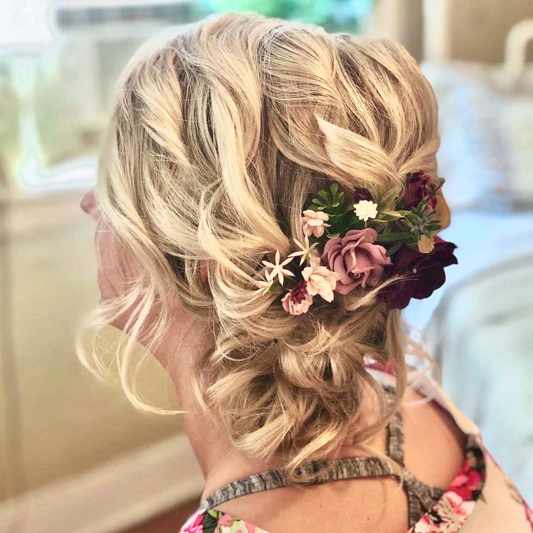 a woman is wearing her hair in a bun with flowers in it