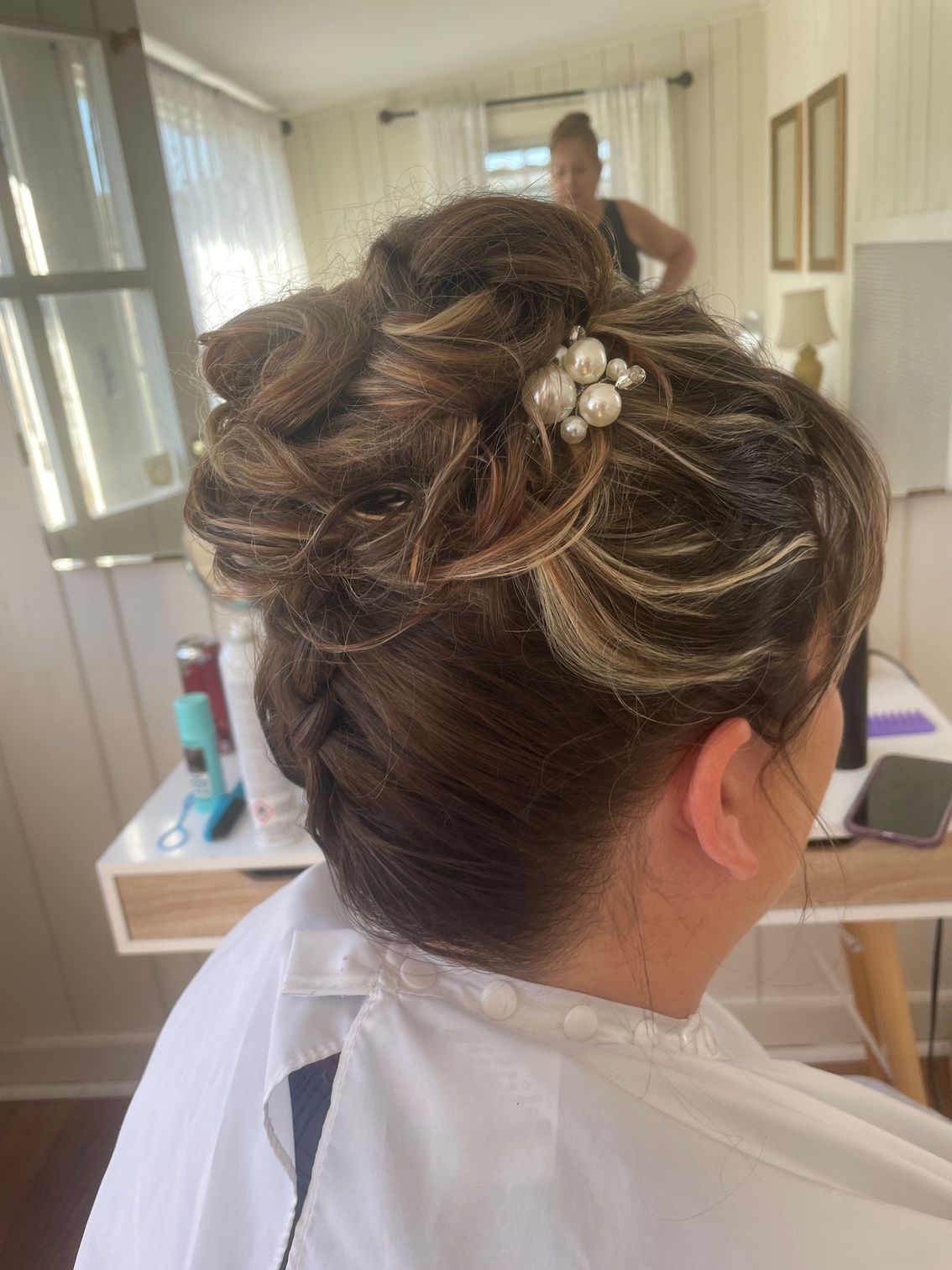 a woman is getting her hair done in a salon for a special event