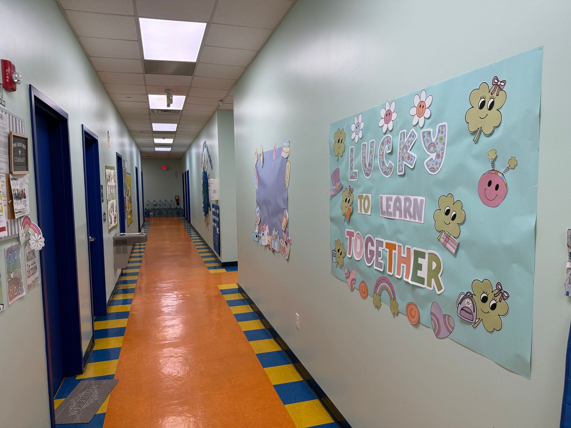 A school hallway with a colorful, decorated bulletin board reading 