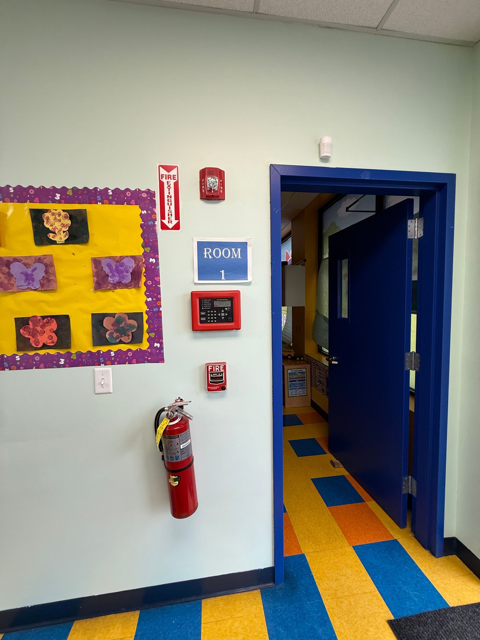 A hallway view of a doorway labeled 