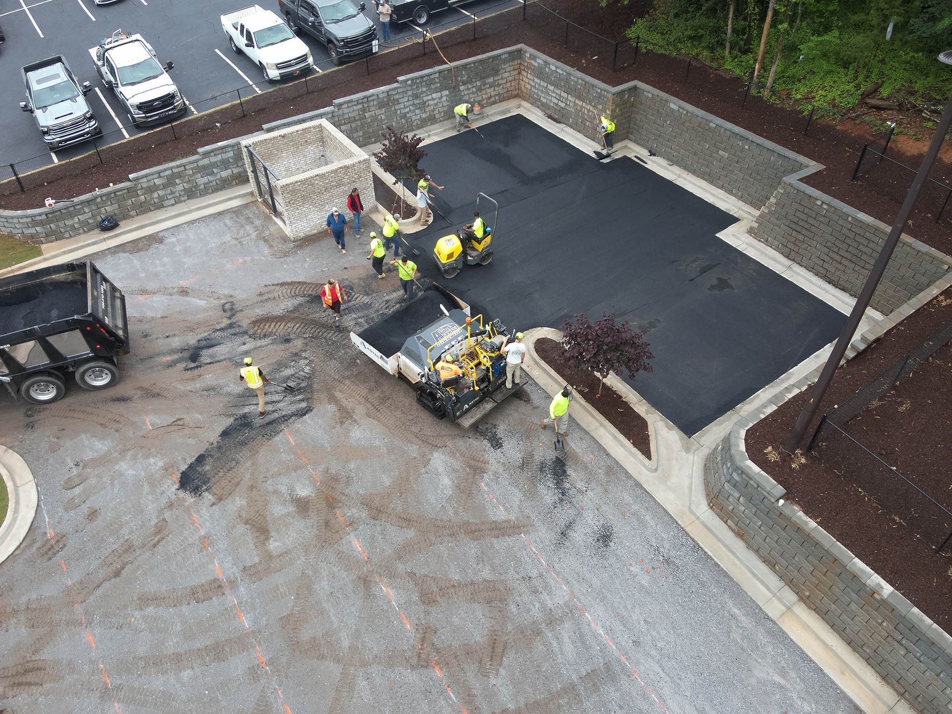 Asphalt paving of a parking area by a construction crew.