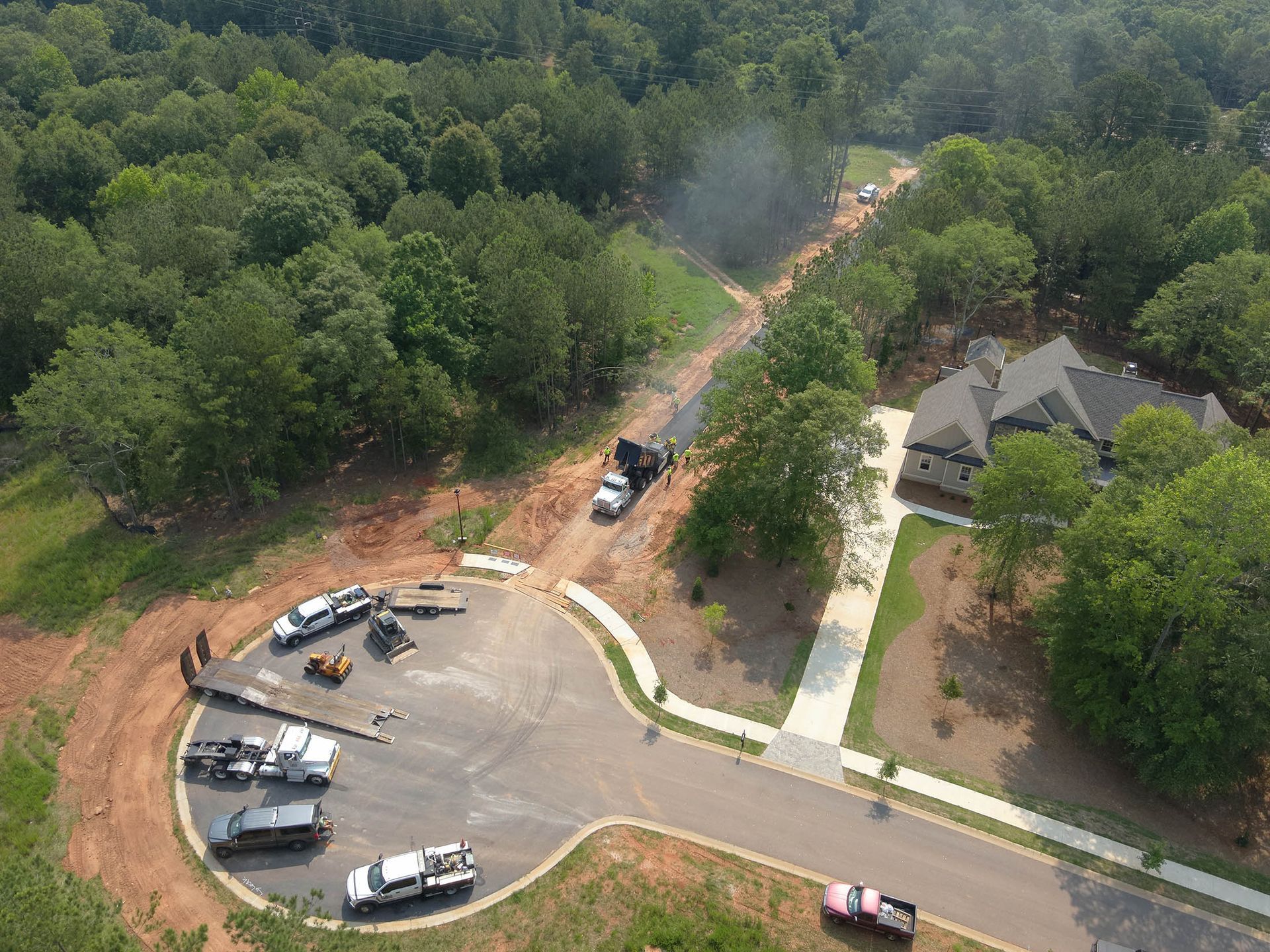 Road paving construction in a residential area, asphalt being laid by a truck.