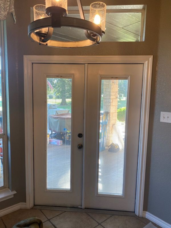 A white door with a chandelier hanging from the ceiling