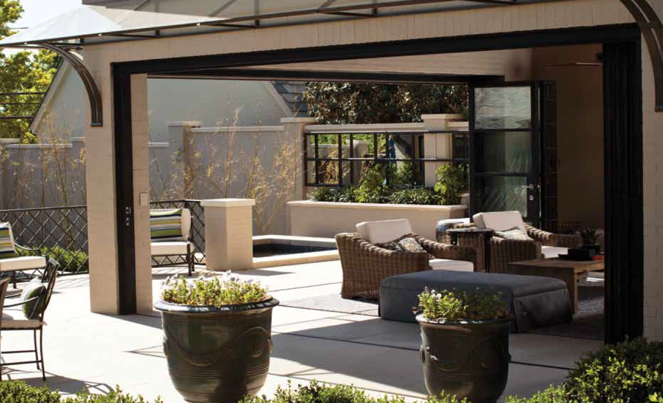 A patio with wicker furniture and potted plants