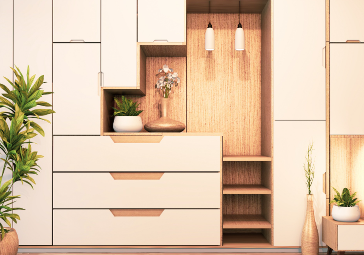 A light-toned wooden modular wall unit with drawers, open shelves, built-in lighting, and decorative potted plants.