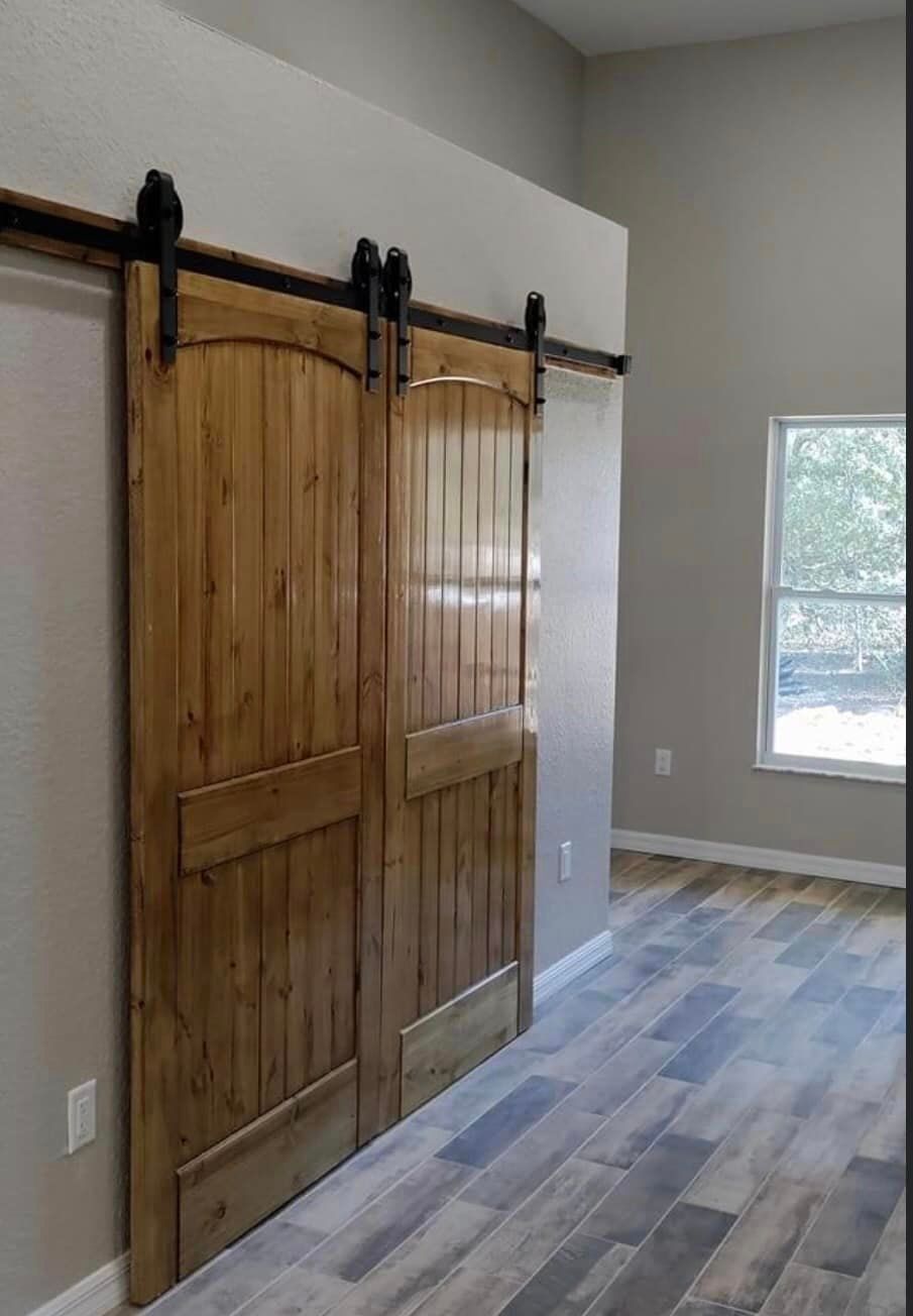 A pair of sliding barn doors in a room with a window
