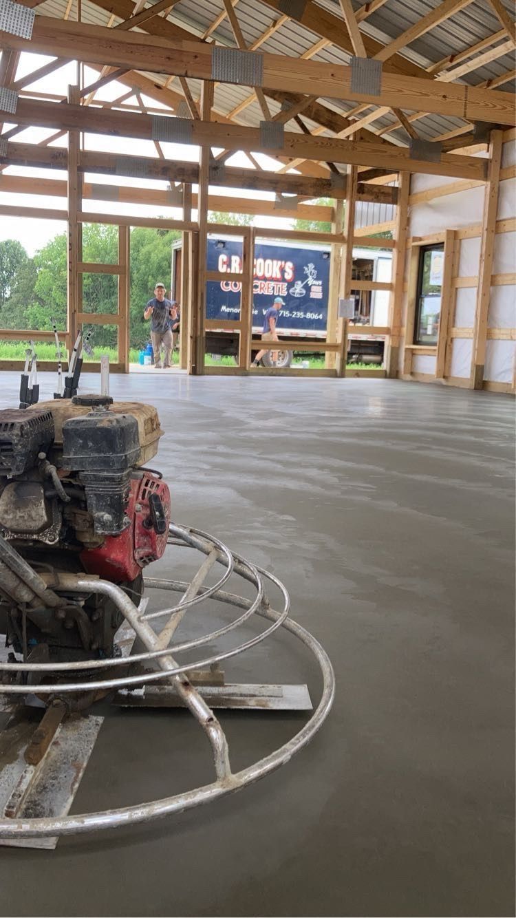 A concrete finisher is sitting on the floor of a building under construction.