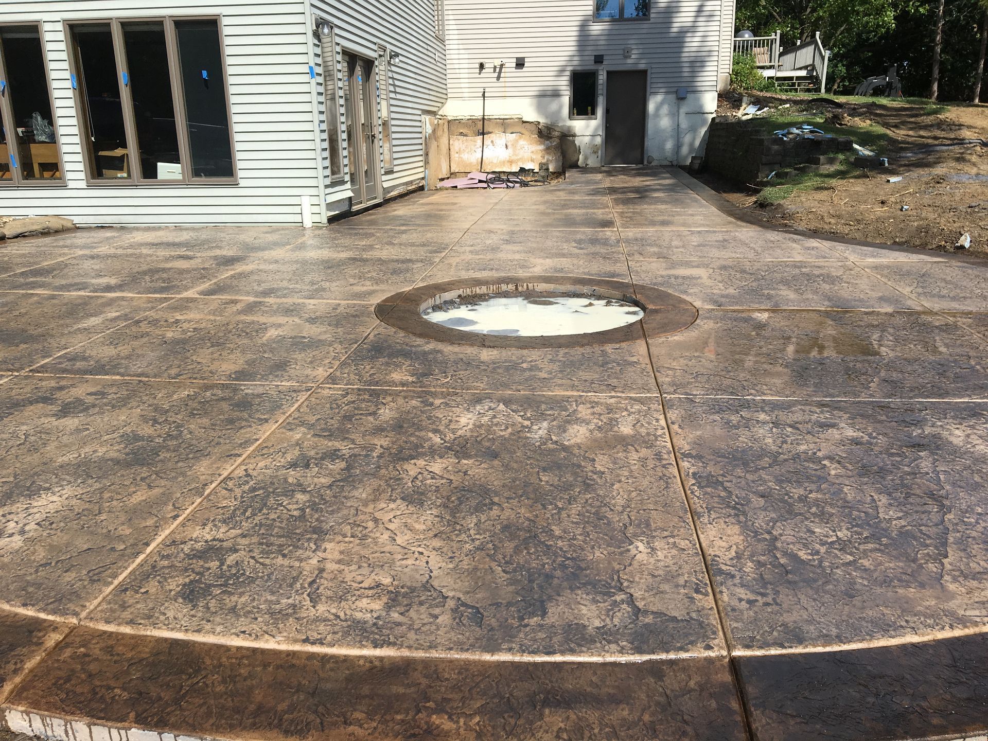 A circular concrete patio with a hole in the middle