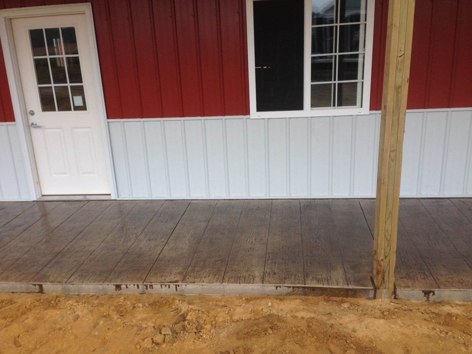 A red and white building with a concrete walkway in front of it
