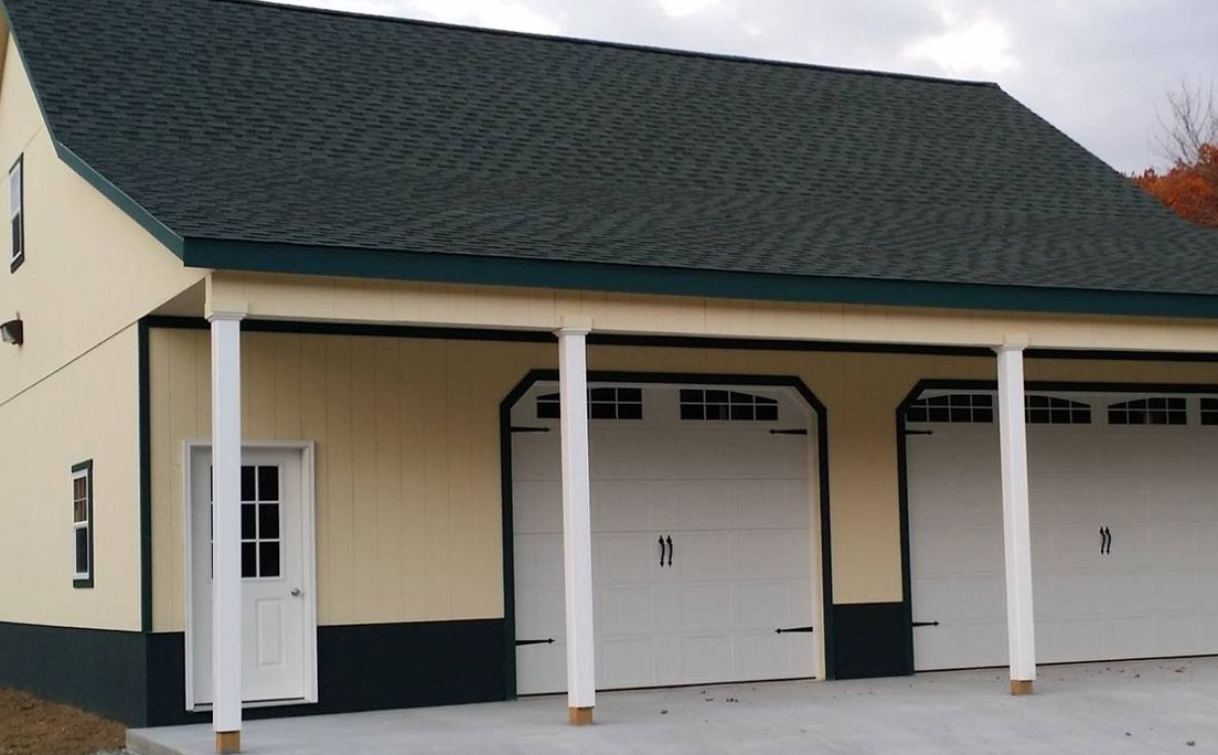Cream-colored garage with white doors and posts under a dark shingled roof.