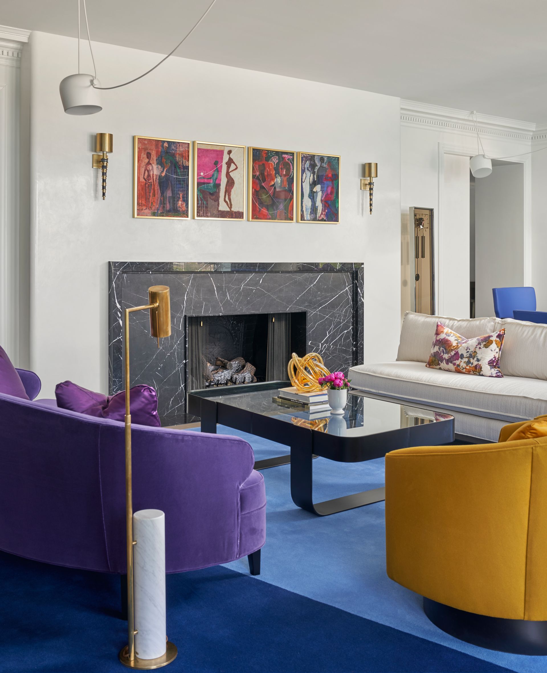 A living room with purple and yellow furniture and a fireplace
