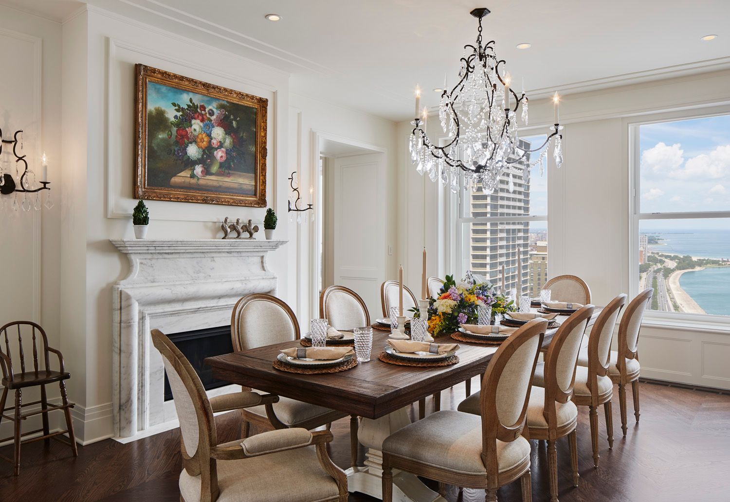 A dining room with a long table and chairs and a fireplace.